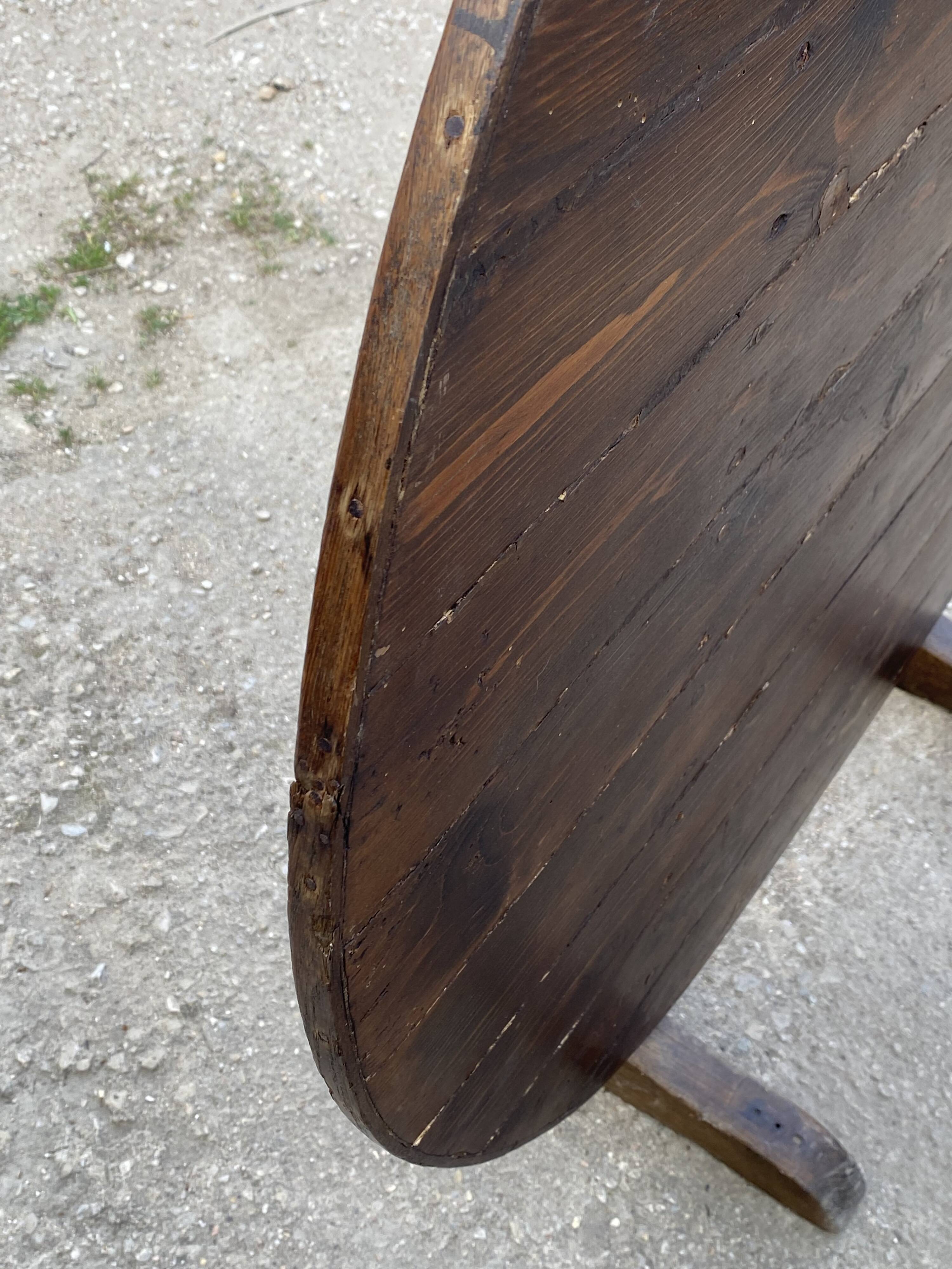 Old folding round winemaker's table with a tilting top.