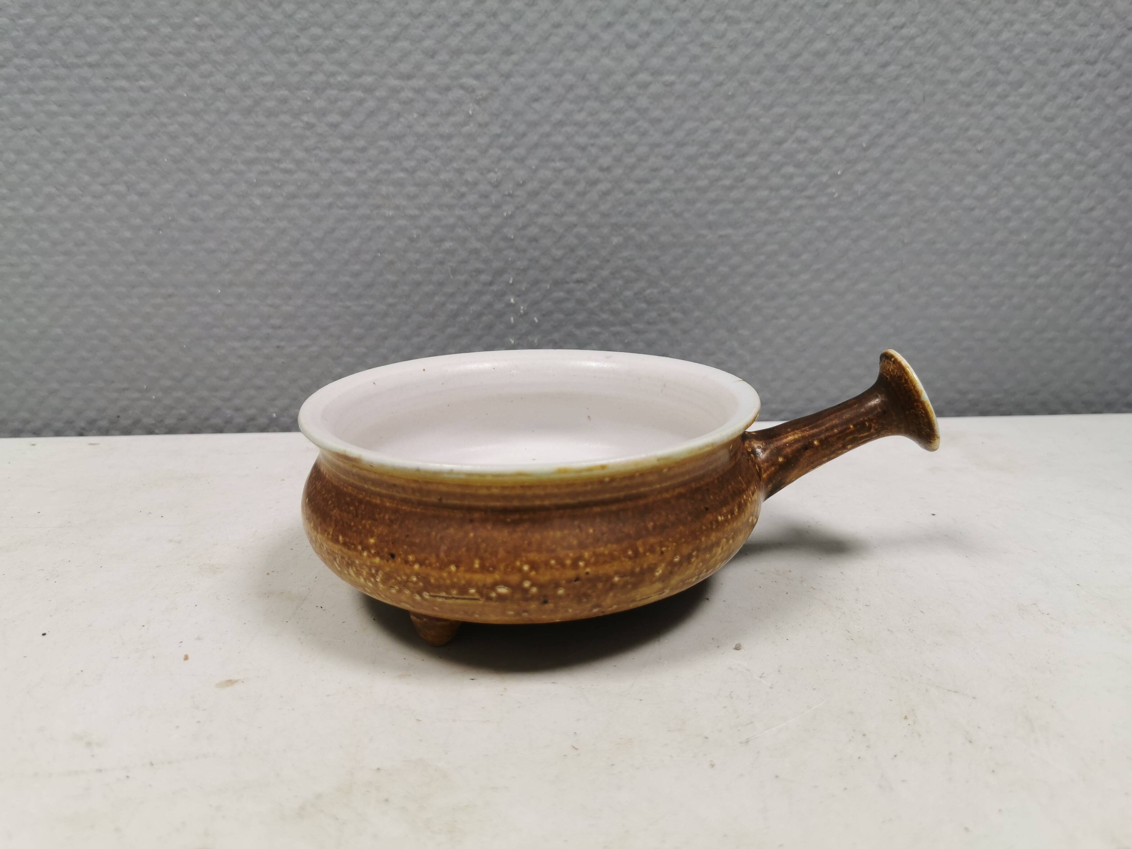 Small ceramic bowl with handle, in golden colours. Danish 1960-70s