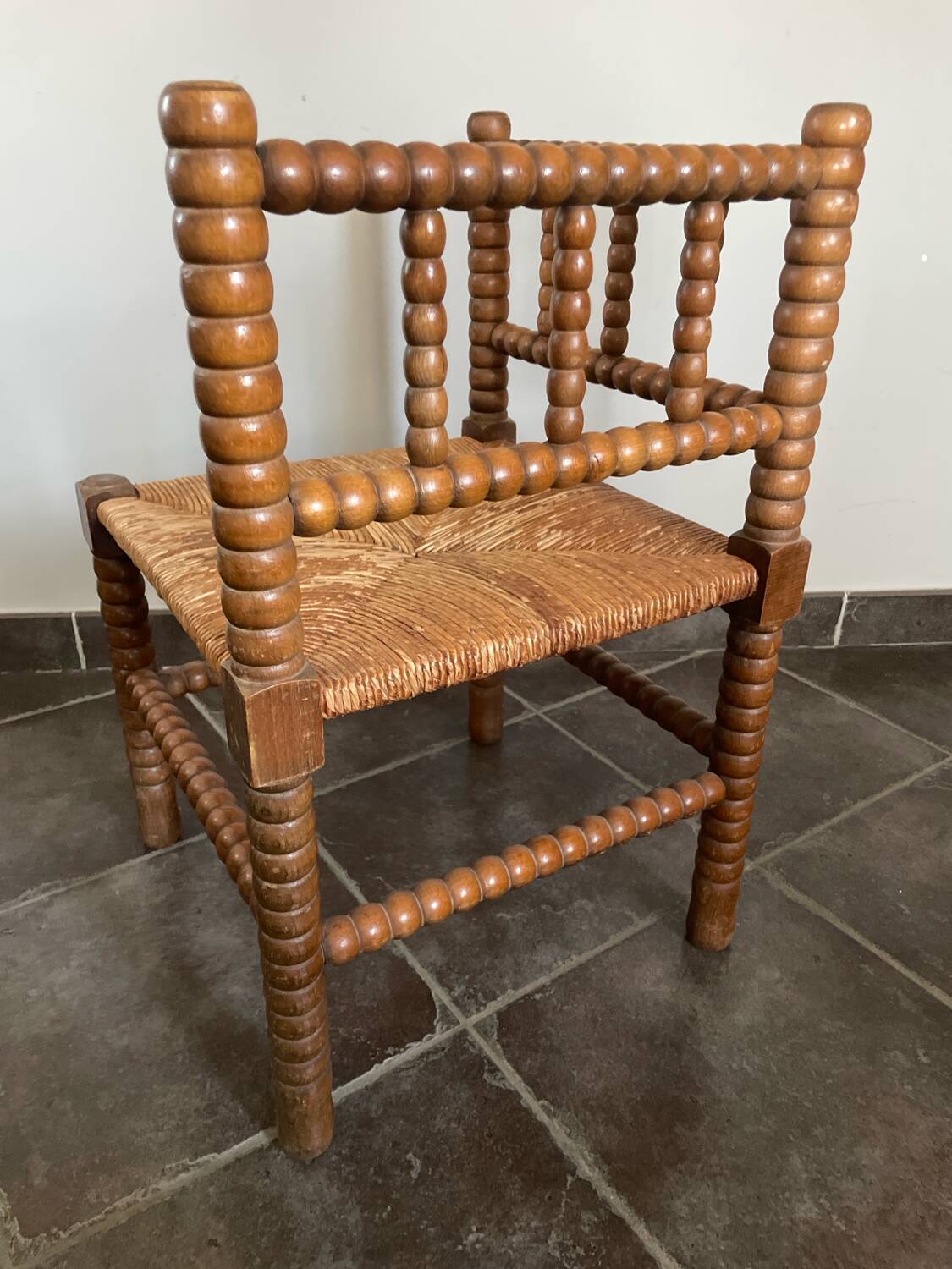 Old armchair, corner chair, made of wood and straw