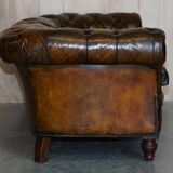 Victorian Chesterfield leather upholstered canapé with feather cushions.