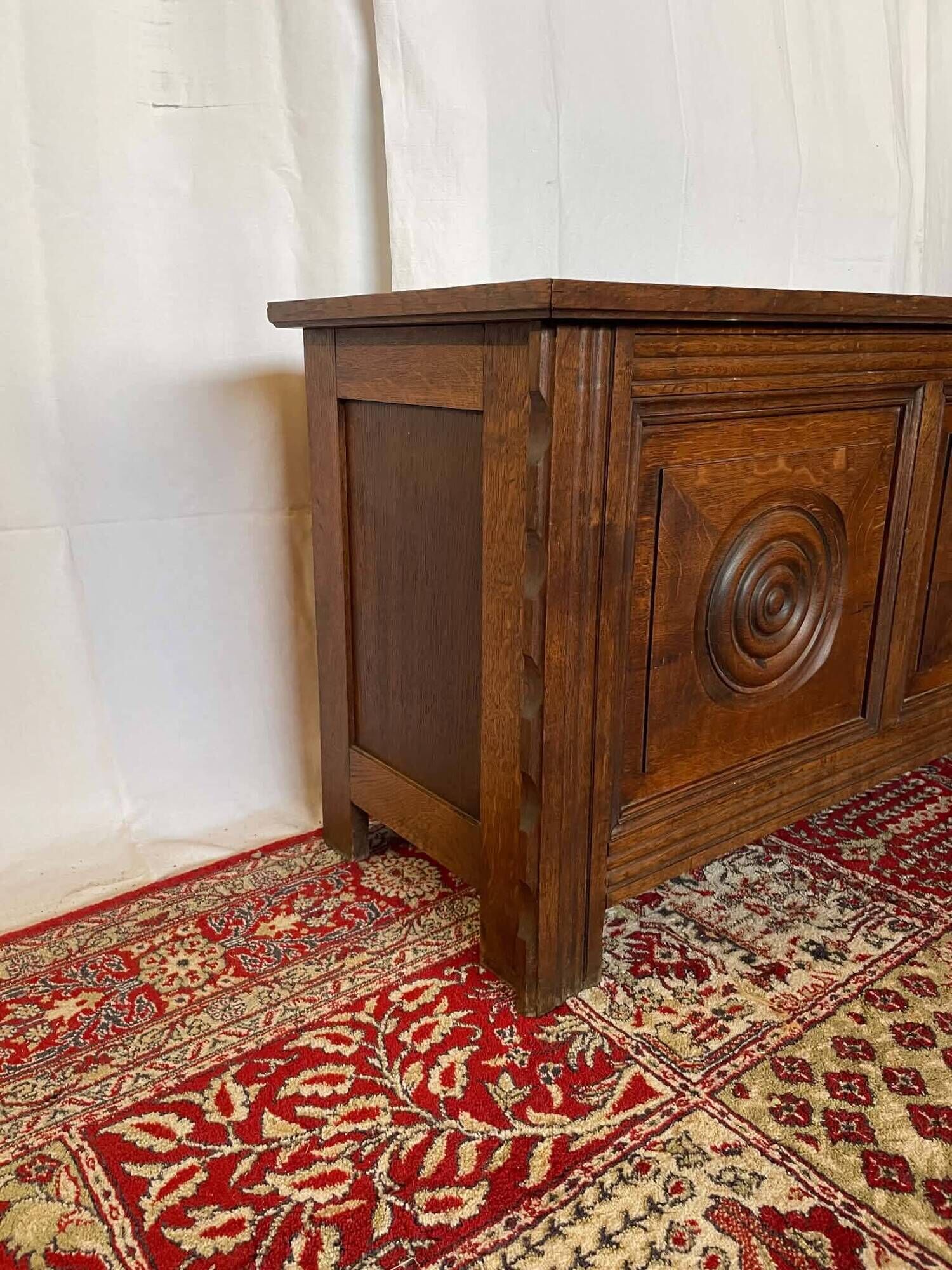Small antique oak chest with carved panels.