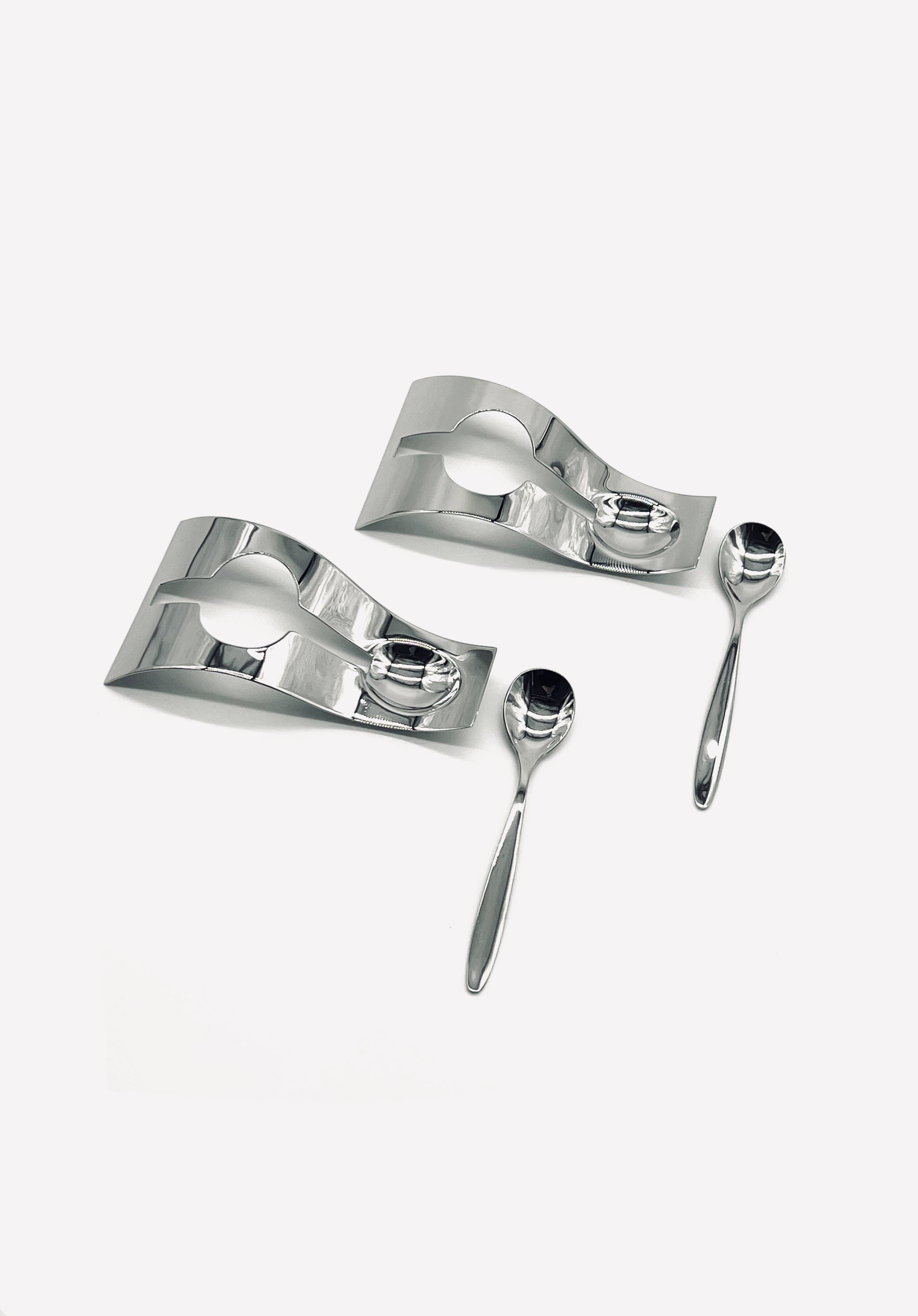 Two egg cups and two stainless steel spoons