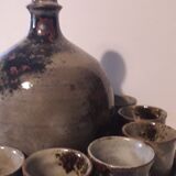 Ceramic liquor service with a decanter and 12 small glasses on tray