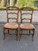 2 solid oak carved and rush-seated chairs in the Louis XV style from the 19th century.