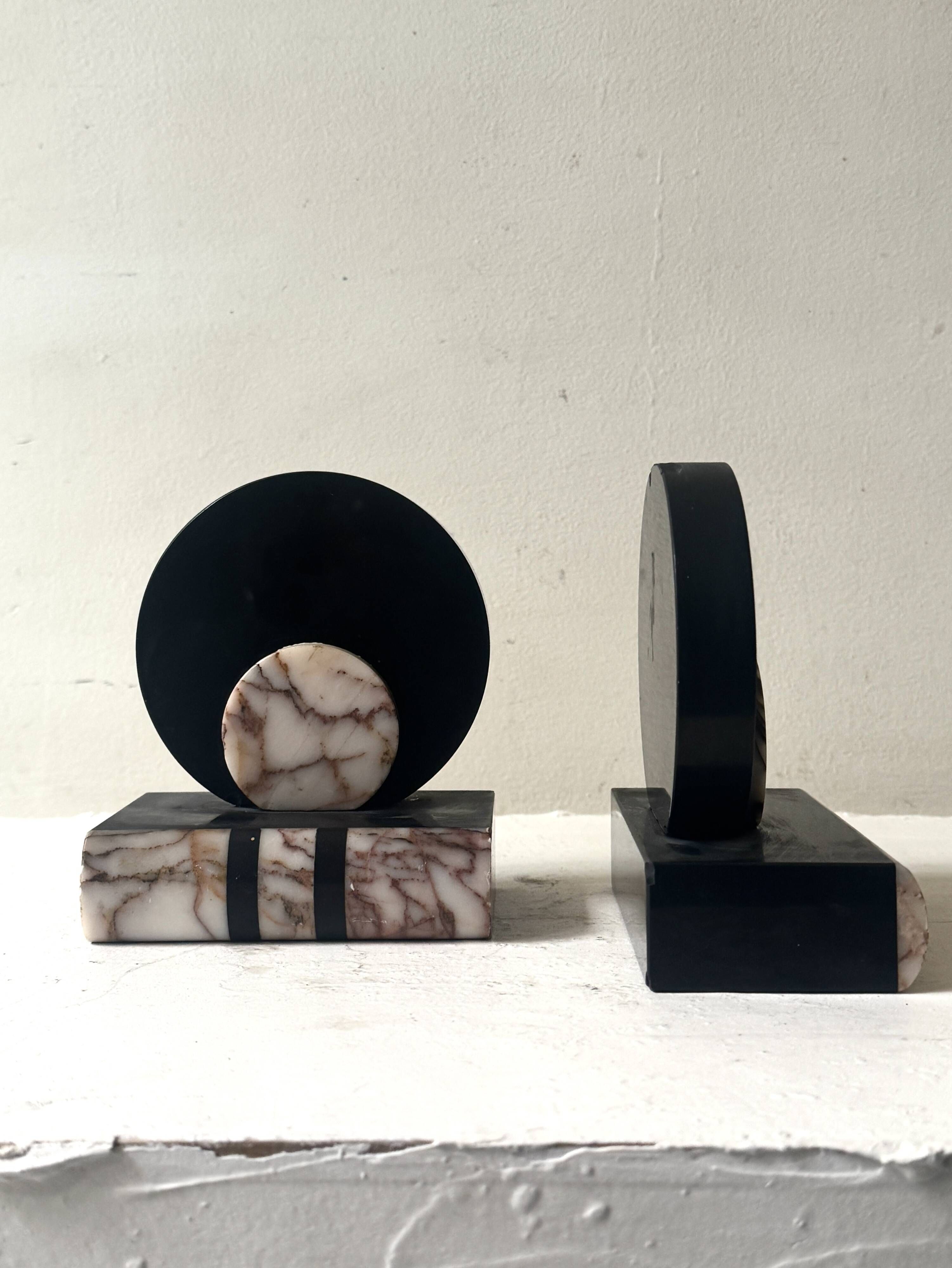 Art Deco bookends with a circular design in black and pink marble.