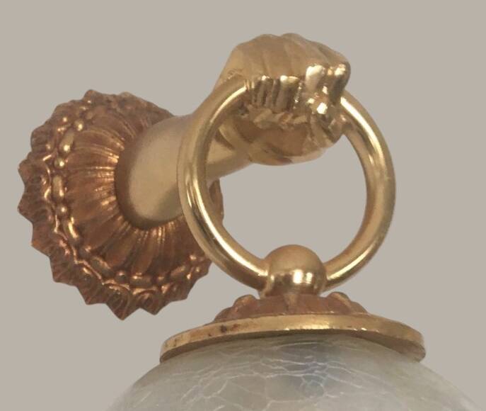 Wall light with golden hand and glass globe