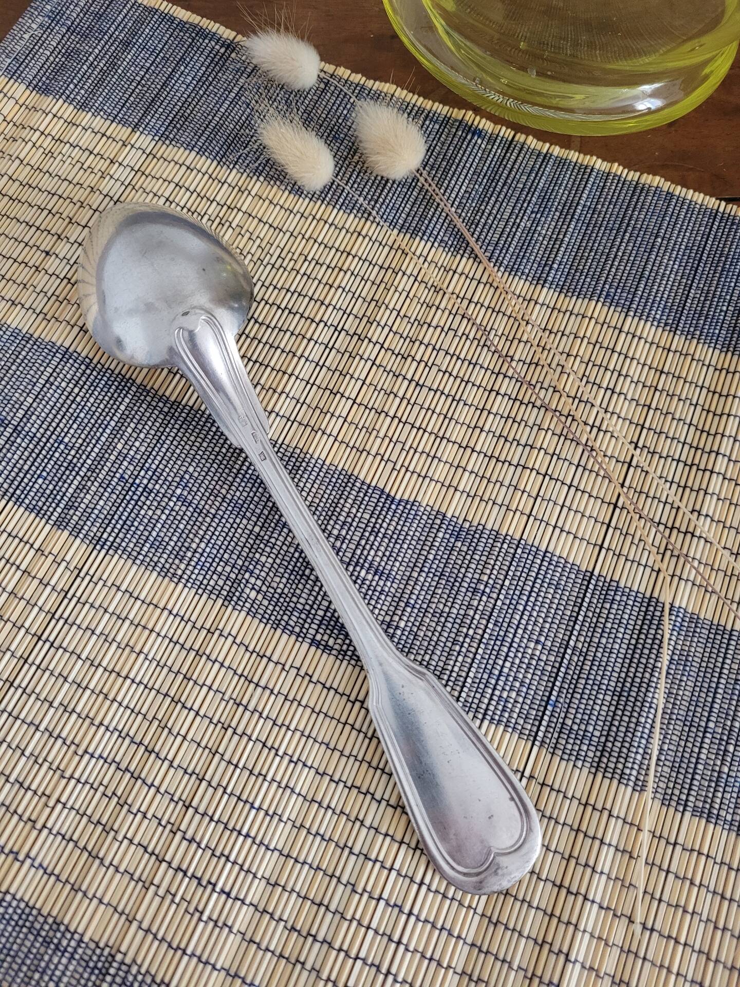 Large silver spoon with net decoration.