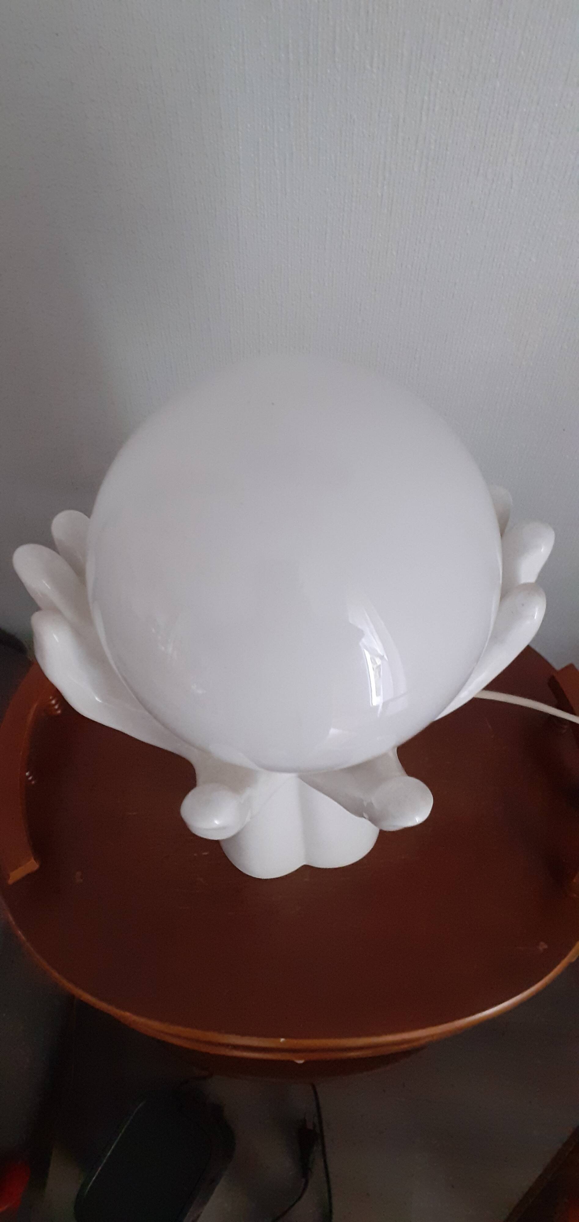 70s lamp two hands embrace an opaline globe