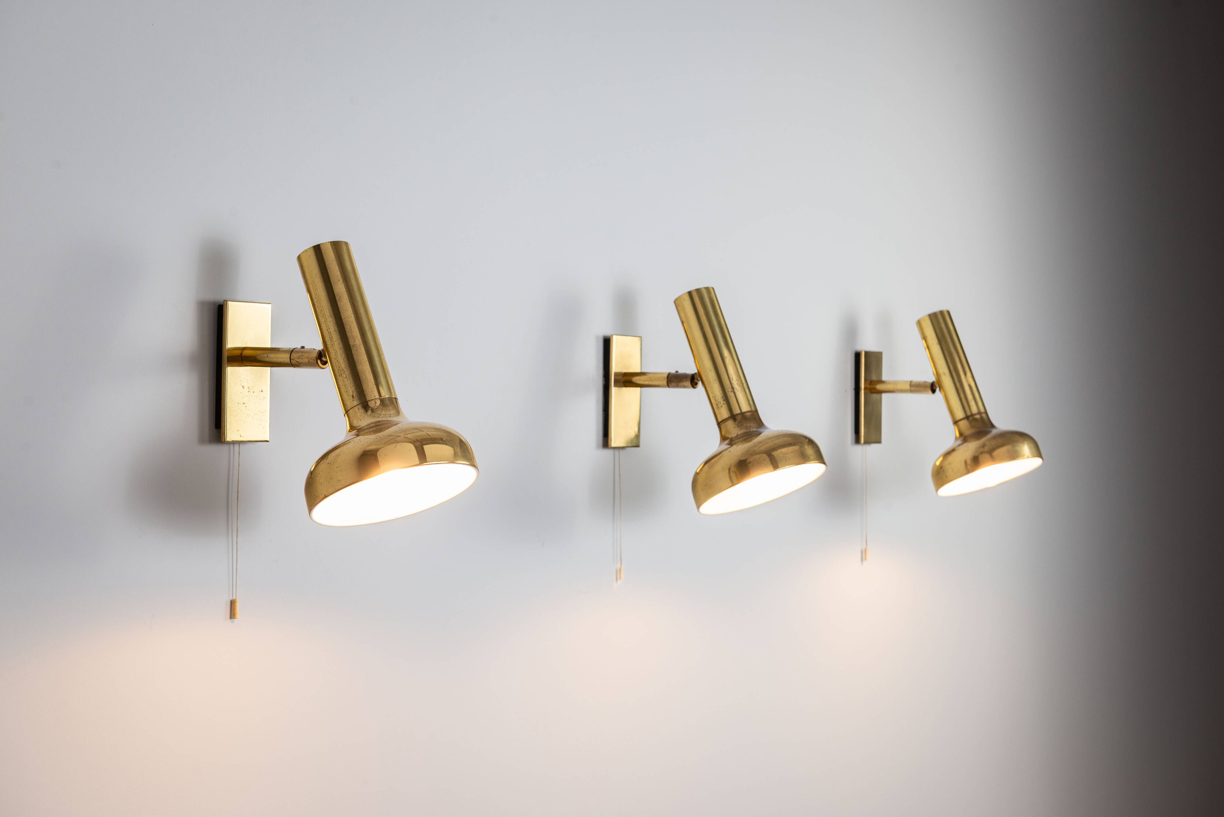 Set of three brass adjustable wall lamps