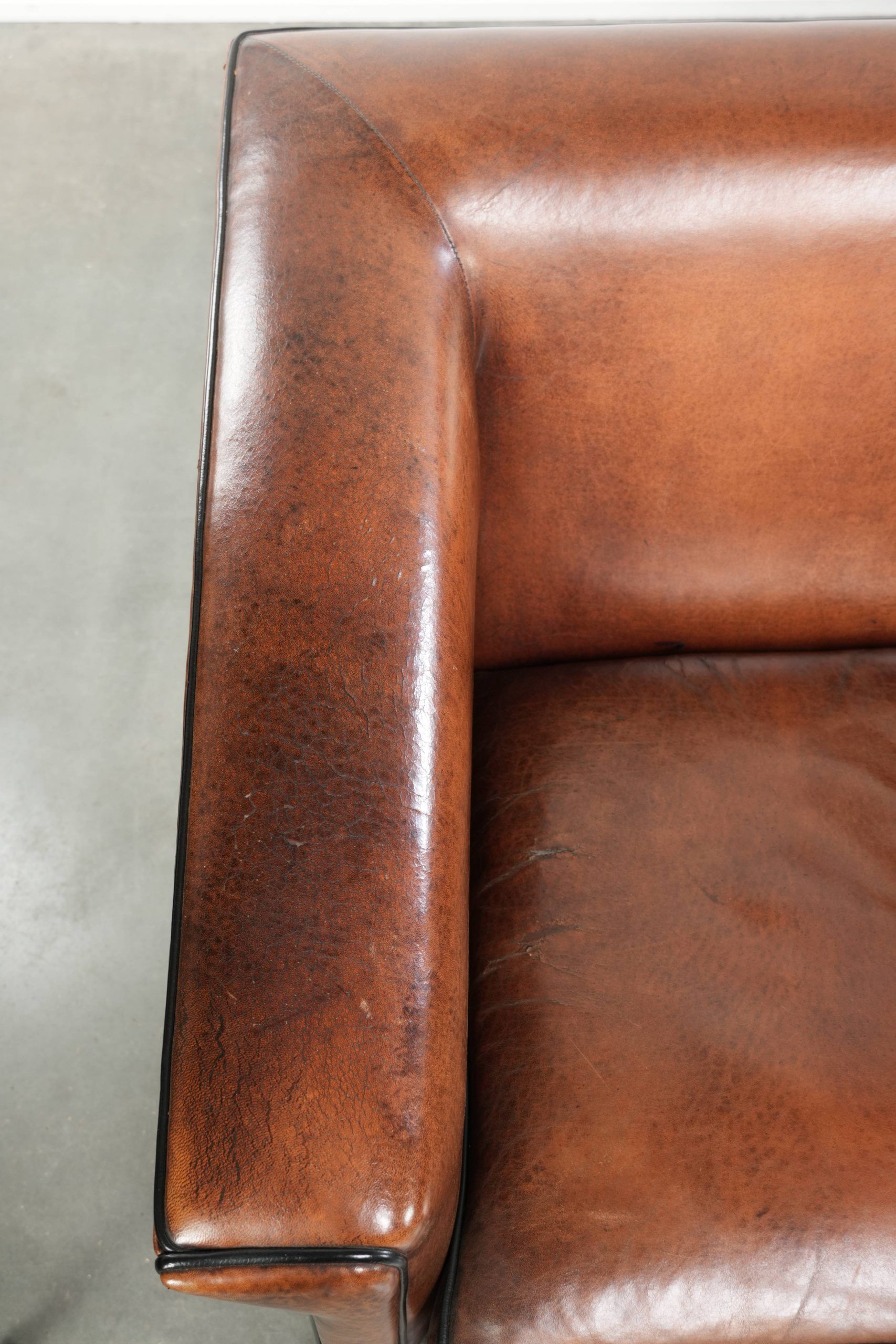 Ensemble de deux fauteuils en peau de mouton au design Art Déco avec passepoil noir.