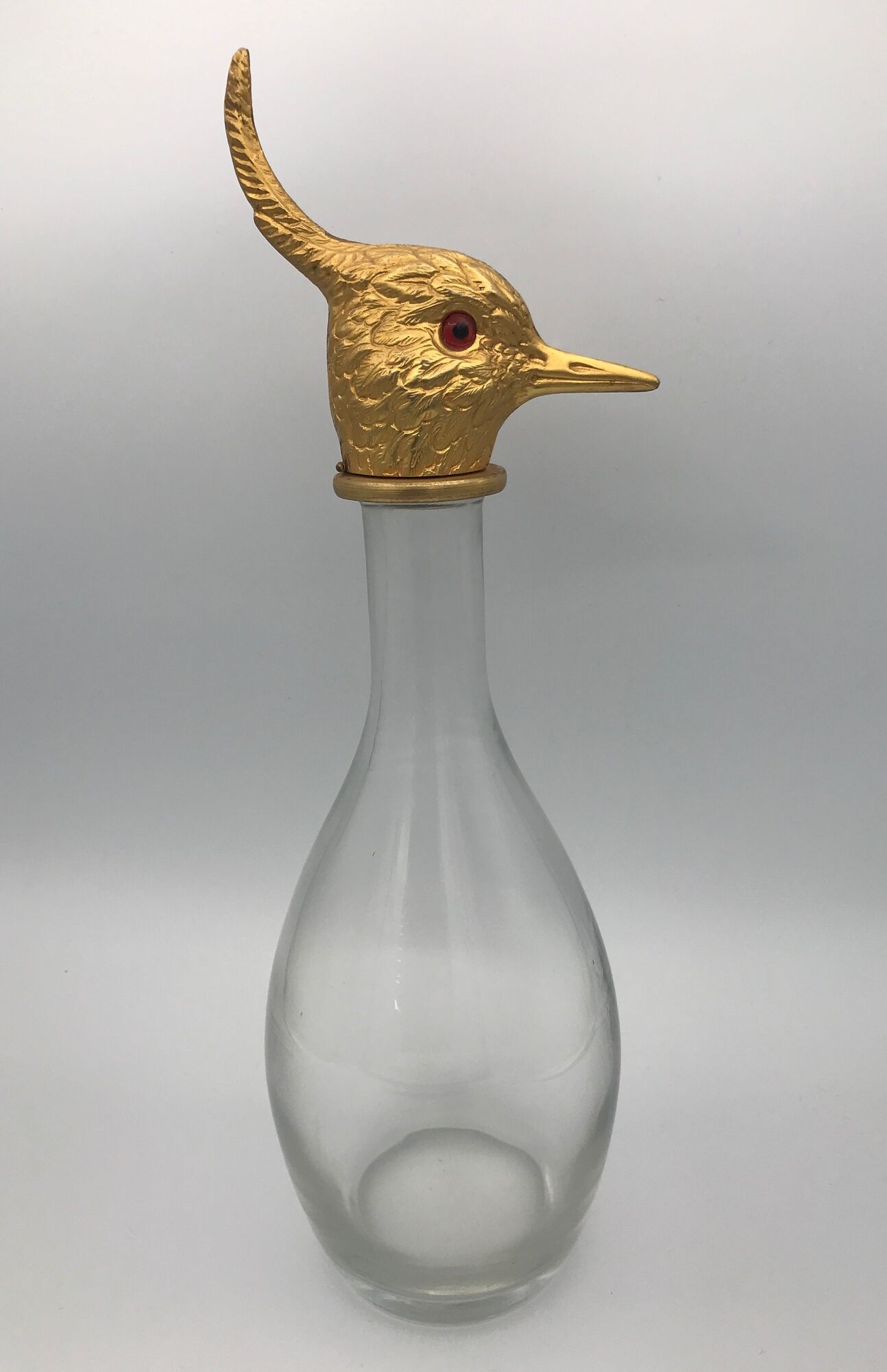 Glass bottle type carafe with gold metal bird head stopper