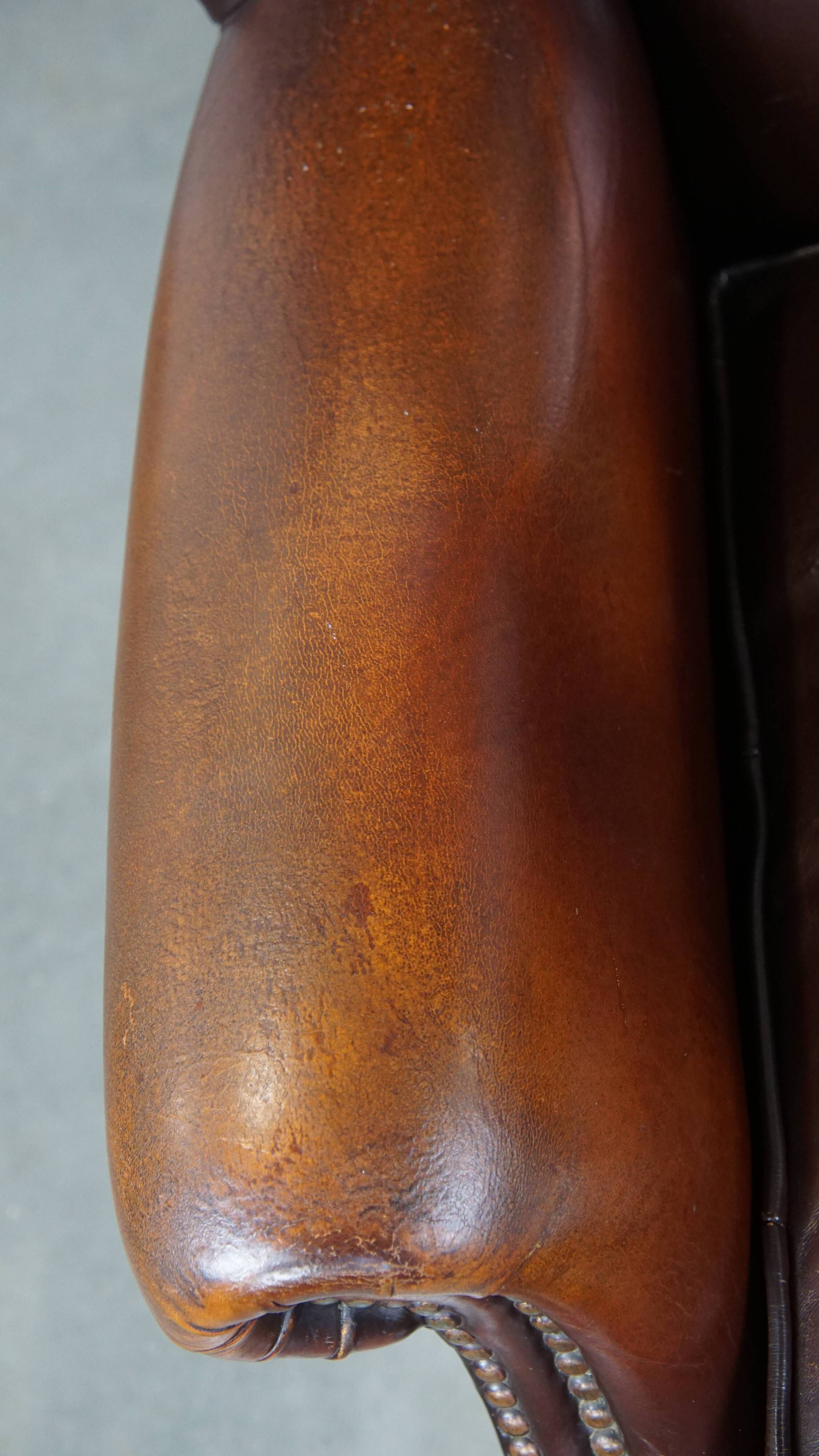 Dark English style sheepskin wingback chair with character and patina