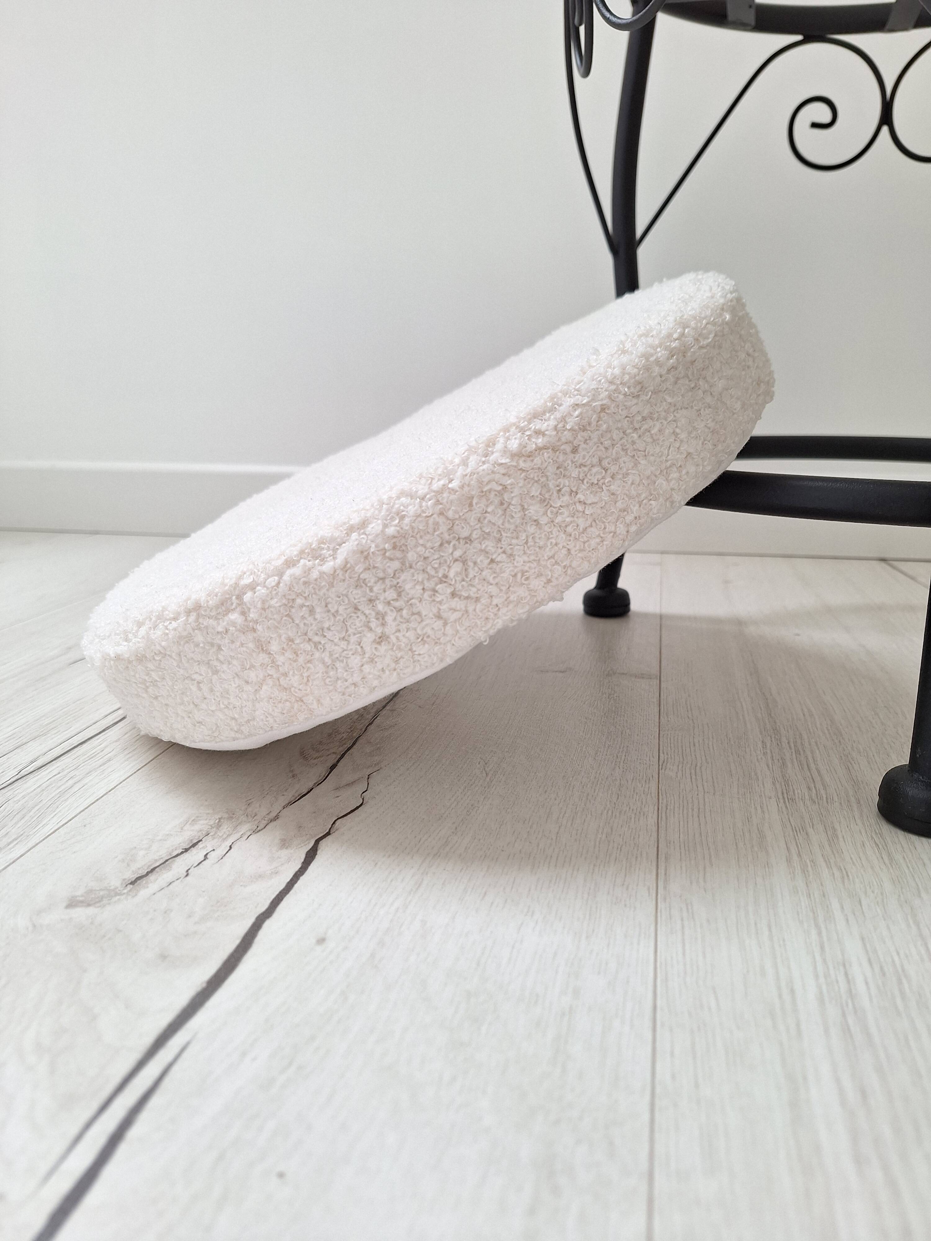 Black iron stool/pouf with its boucle fabric cushion.