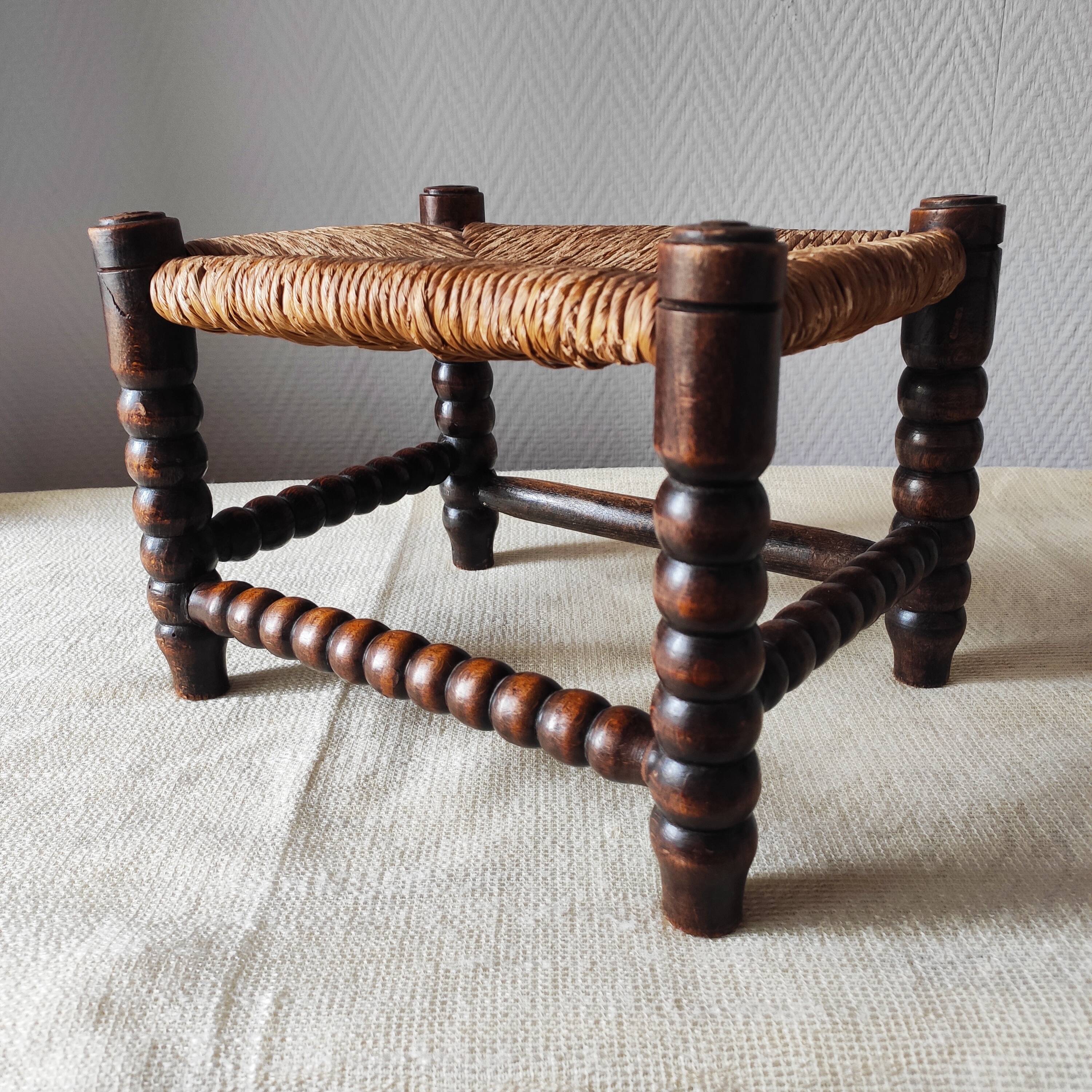 Antique wooden turned spool footrest with straw.