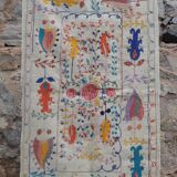 White suzani kilim rug with embroidered colorful patterns