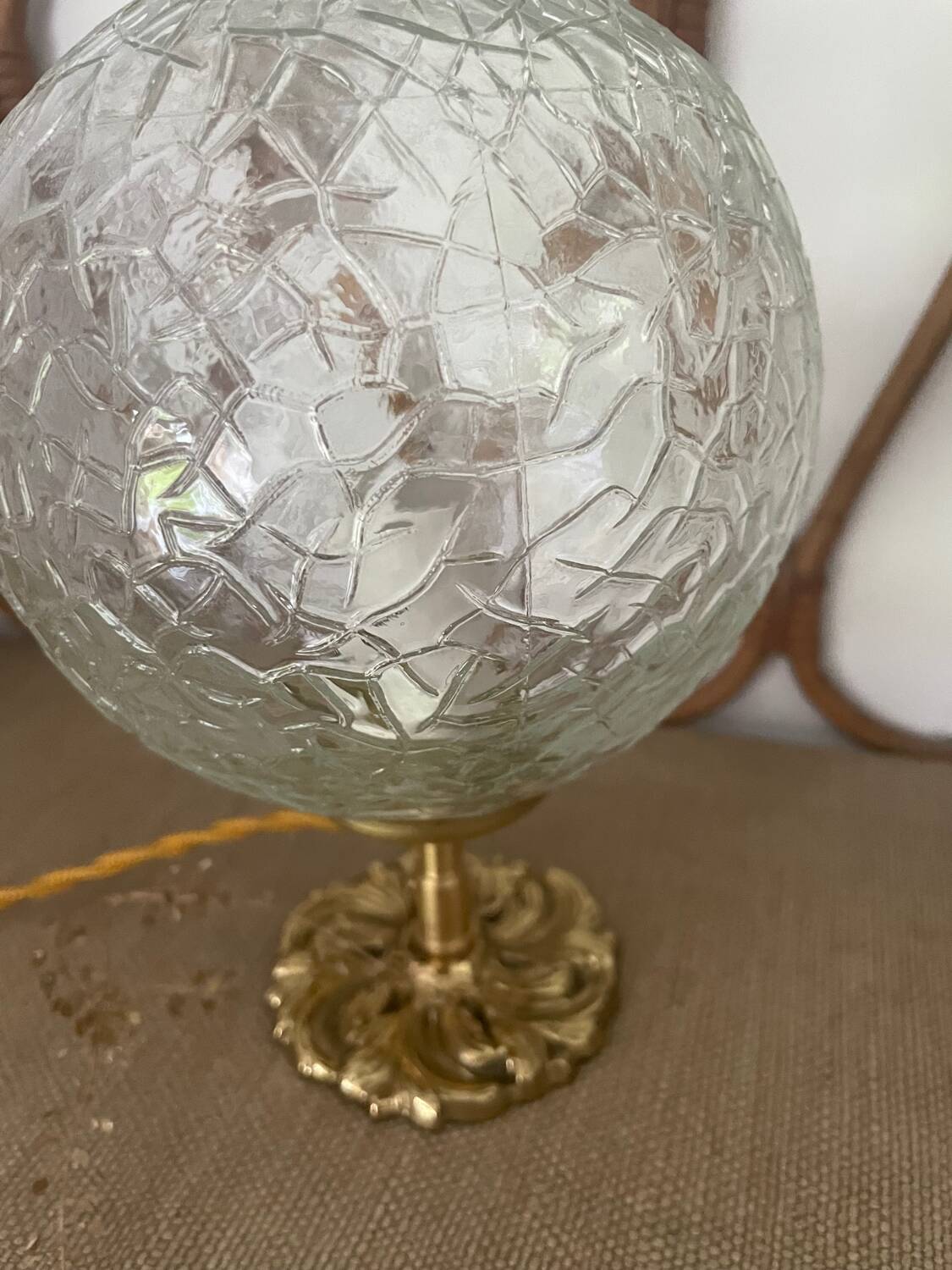 Small handcrafted globe lamp with a cracked finish and a golden brass base.