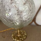 Small handcrafted globe lamp with a cracked finish and a golden brass base.