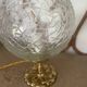 Small handcrafted globe lamp with a cracked finish and a golden brass base.