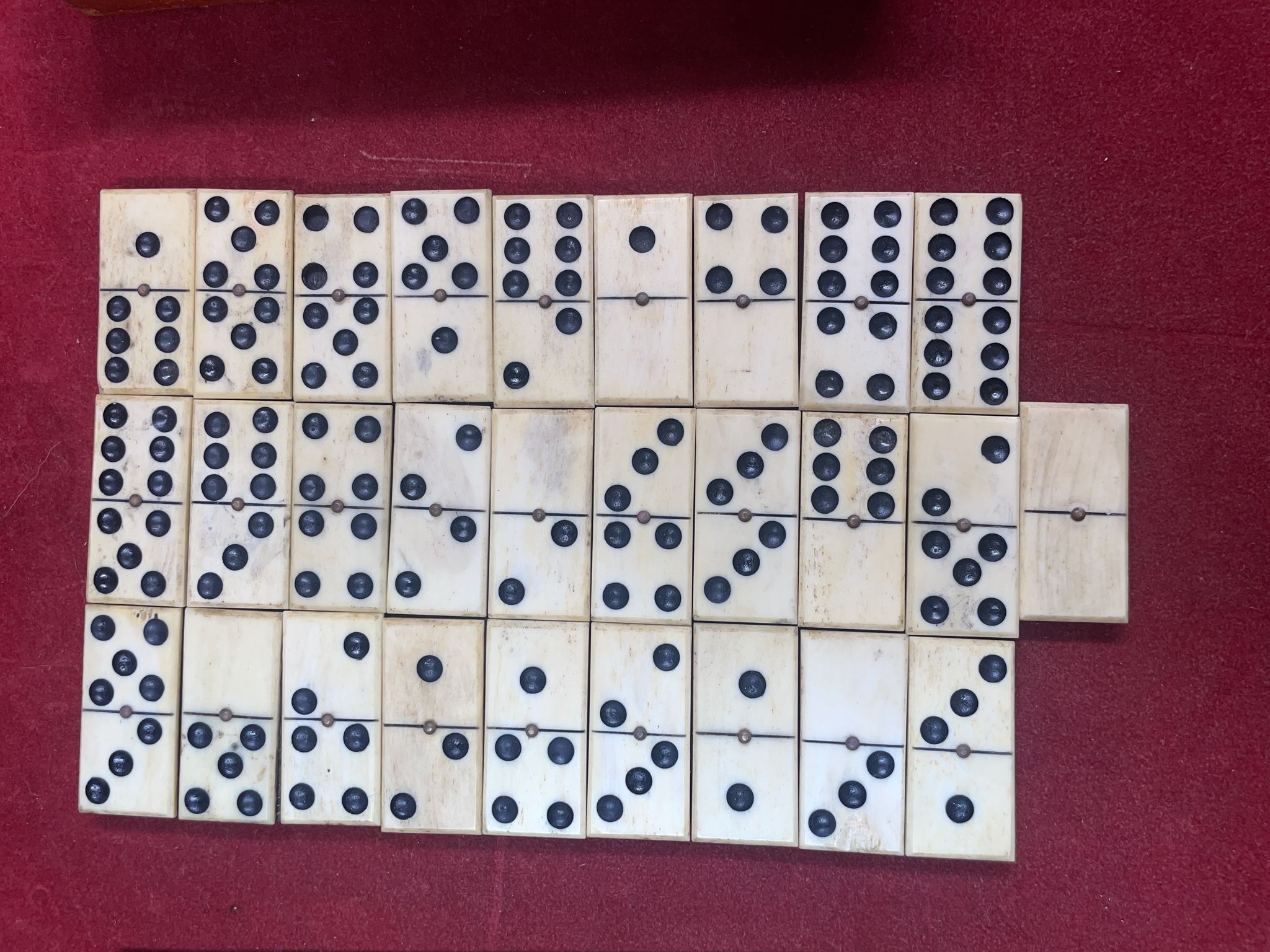 Set of complete dominoes made of bone, nails and blackened wood