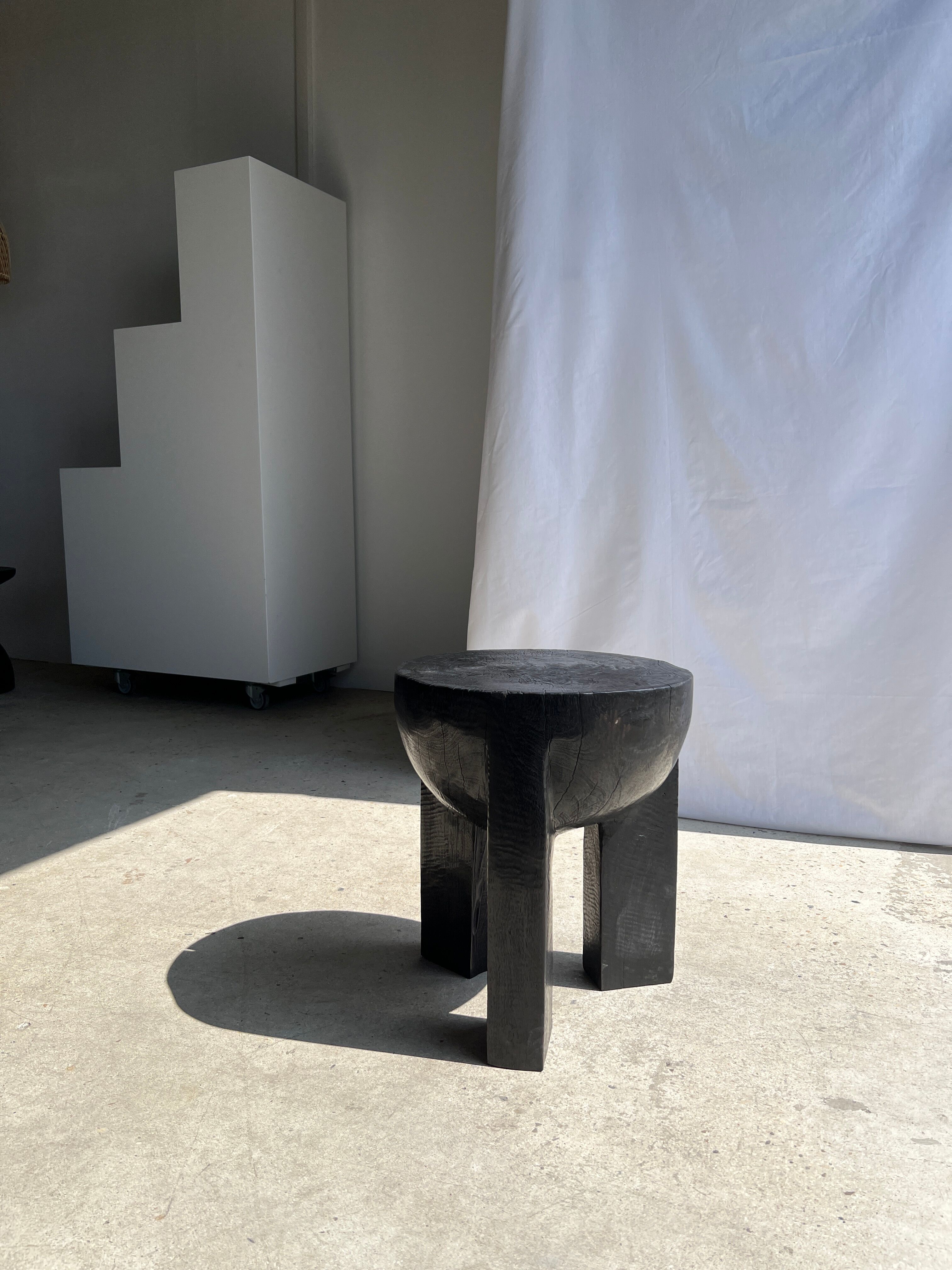 Black mango wood tripod side table with a semi-spherical top, height: 45 cm, diameter: 44 cm.