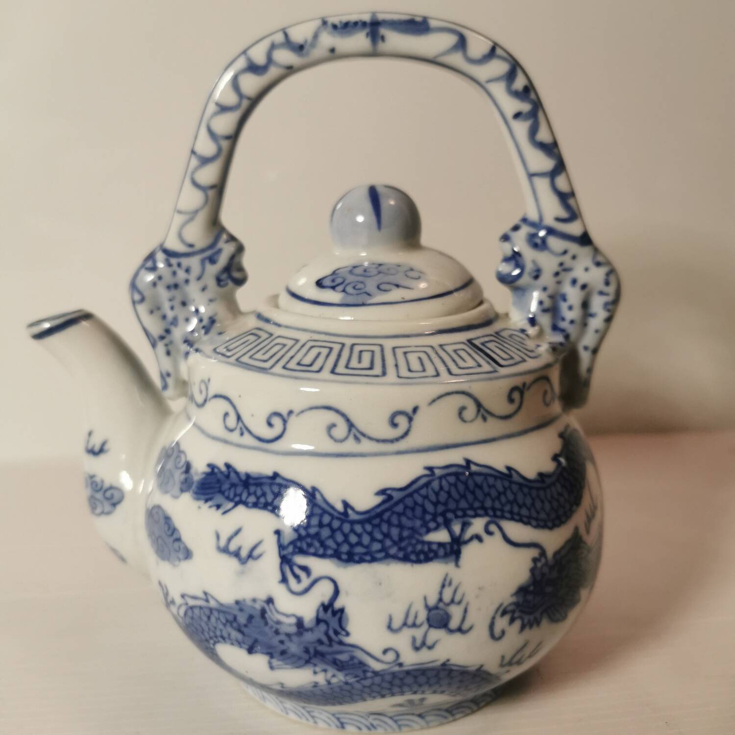 Old Chinese blue and white teapot in vintage ceramic with dragon decor