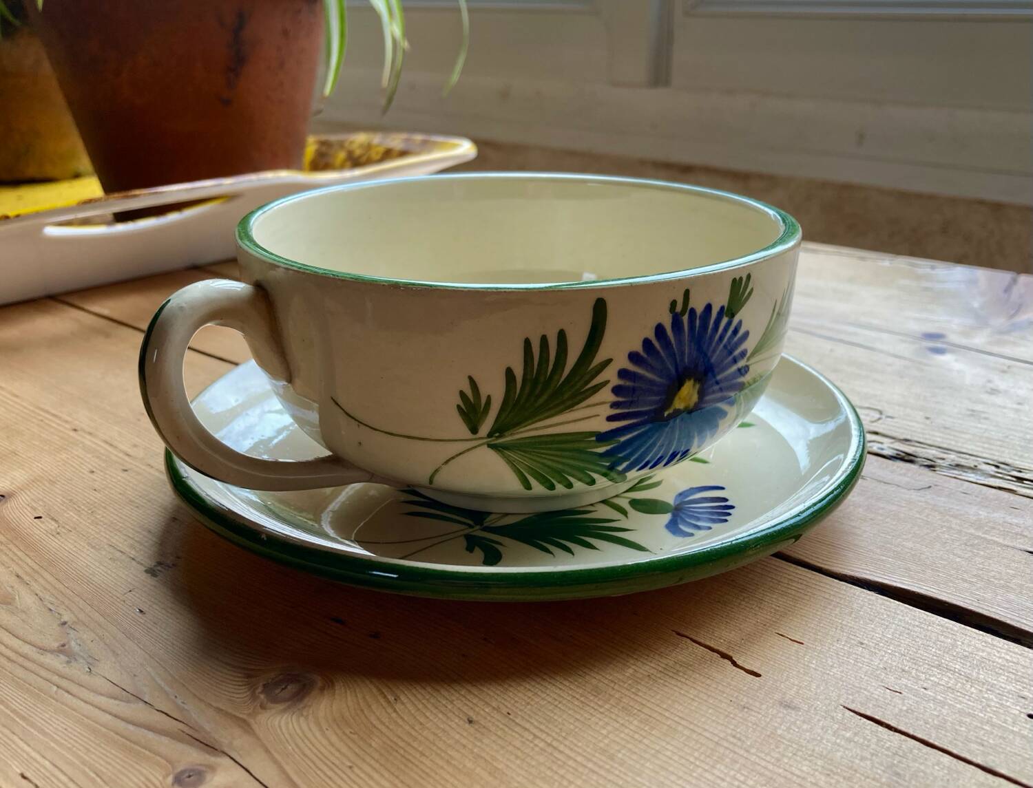 Large cup and saucer in the quimper earthenware style.