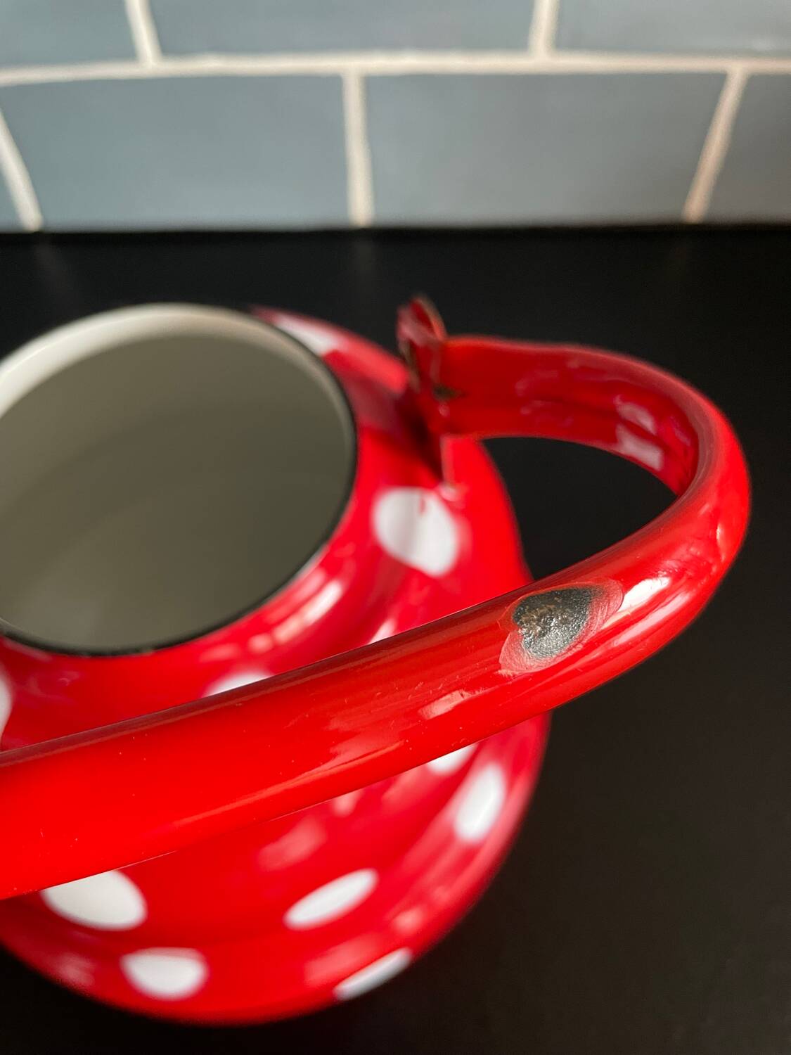 Red enameled sheet metal kettle with white polka dots