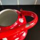 Red enameled sheet metal kettle with white polka dots