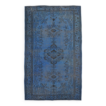 Vintage blue and black Turkish rug with traditional design, 163 × 268 cm