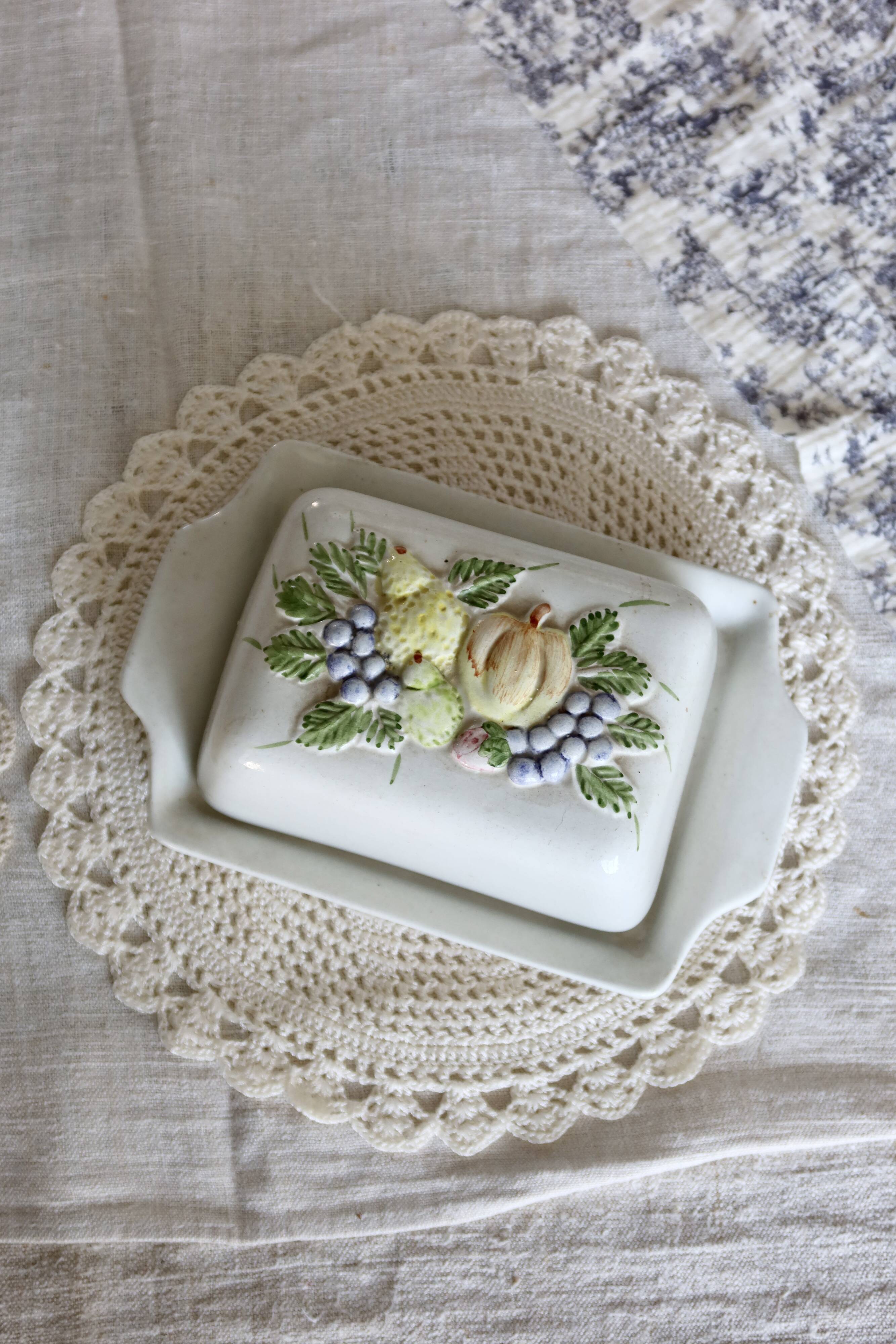 Large vintage faience butter dish with a fruit motif.