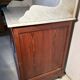 Antique wood and marble kitchen sideboard with carved backsplash