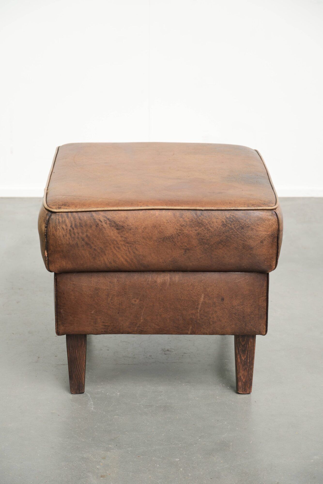 Sheepskin ottoman with a light brown colour scheme and a vintage look