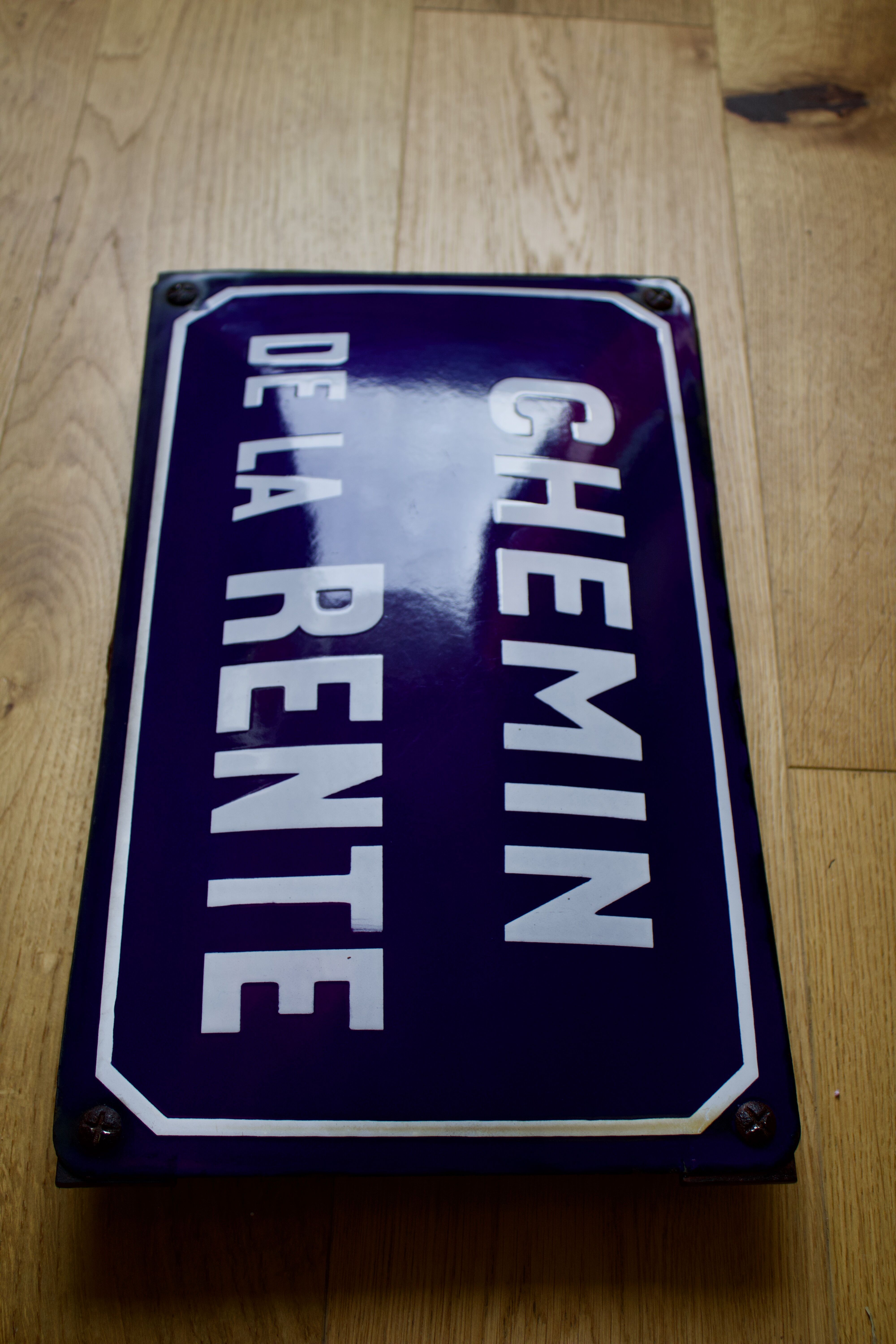 Old Enamelled and bulging "Chemin de la Rente" street plate, in perfect condition, on its cast iron support