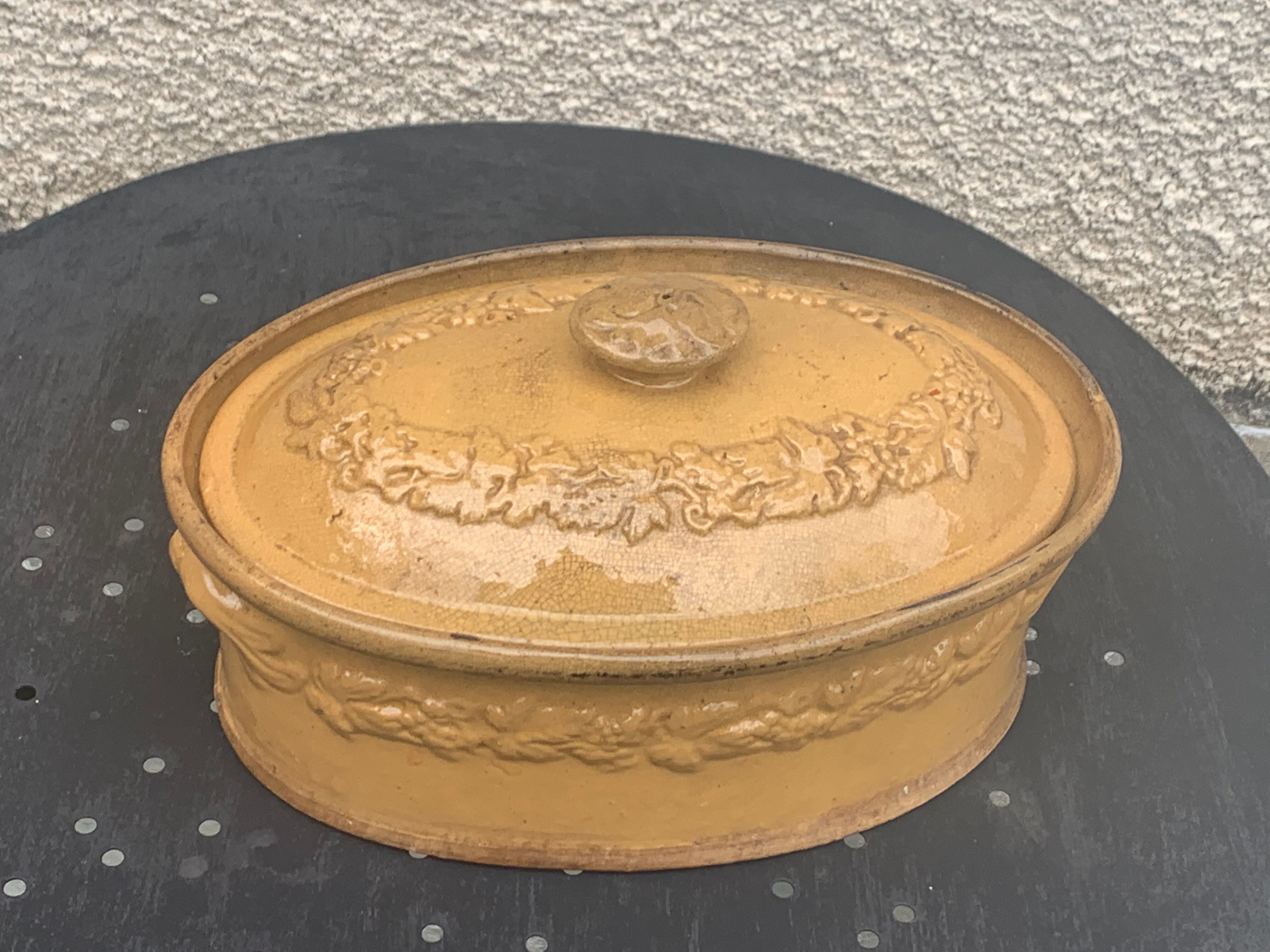 Old terrine in glazed stoneware and floral decoration mustard yellow slip
