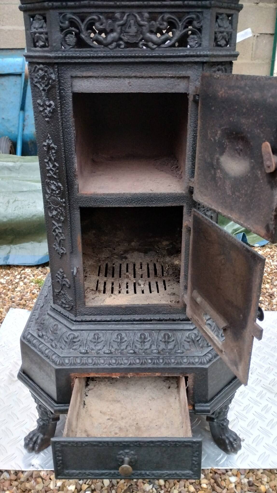Black cast iron wood burning stove with solid brass handle.