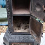 Black cast iron wood burning stove with solid brass handle.