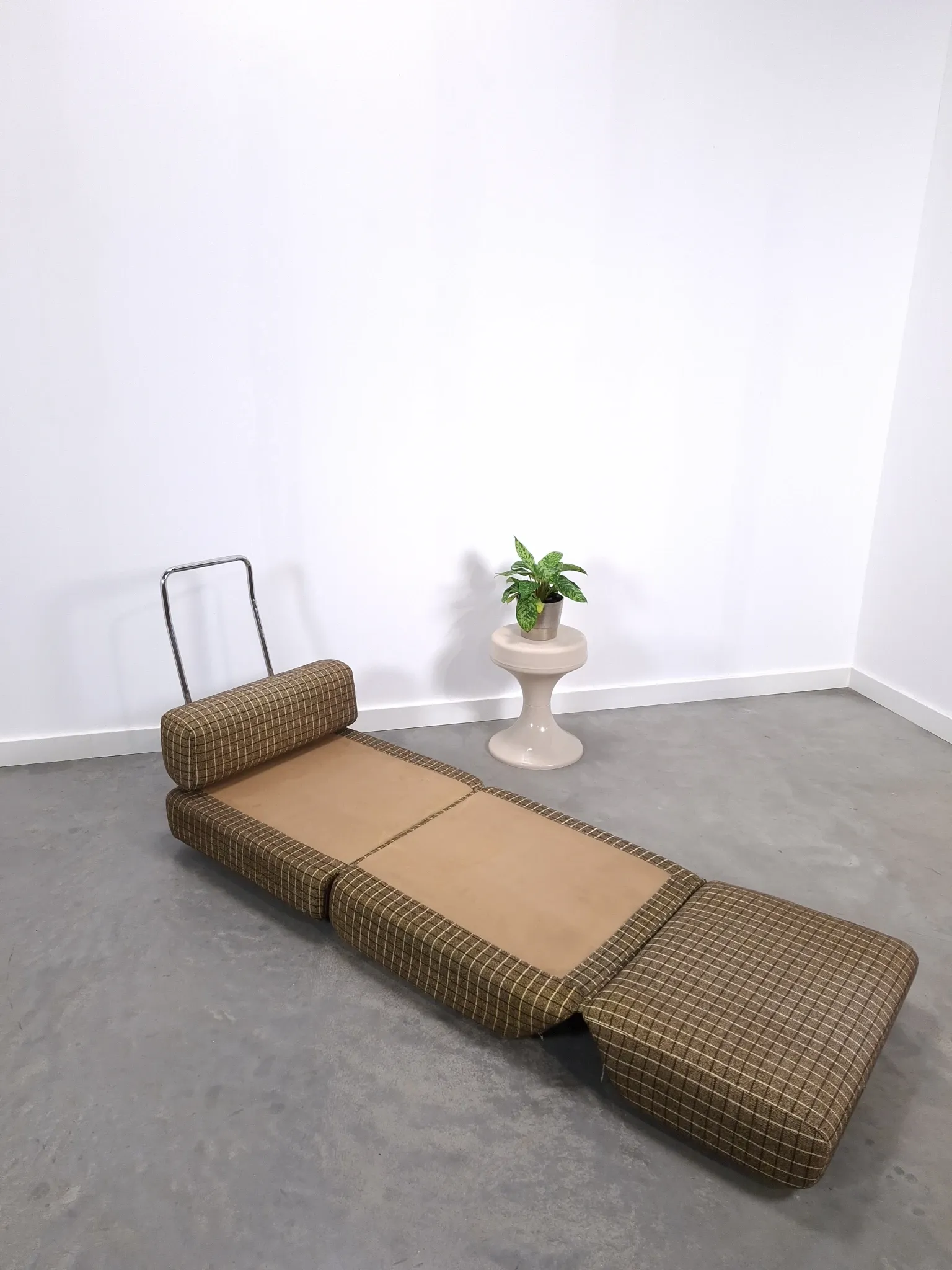 Vintage pull-out sofa bed, brown checked lounge chair with chrome.