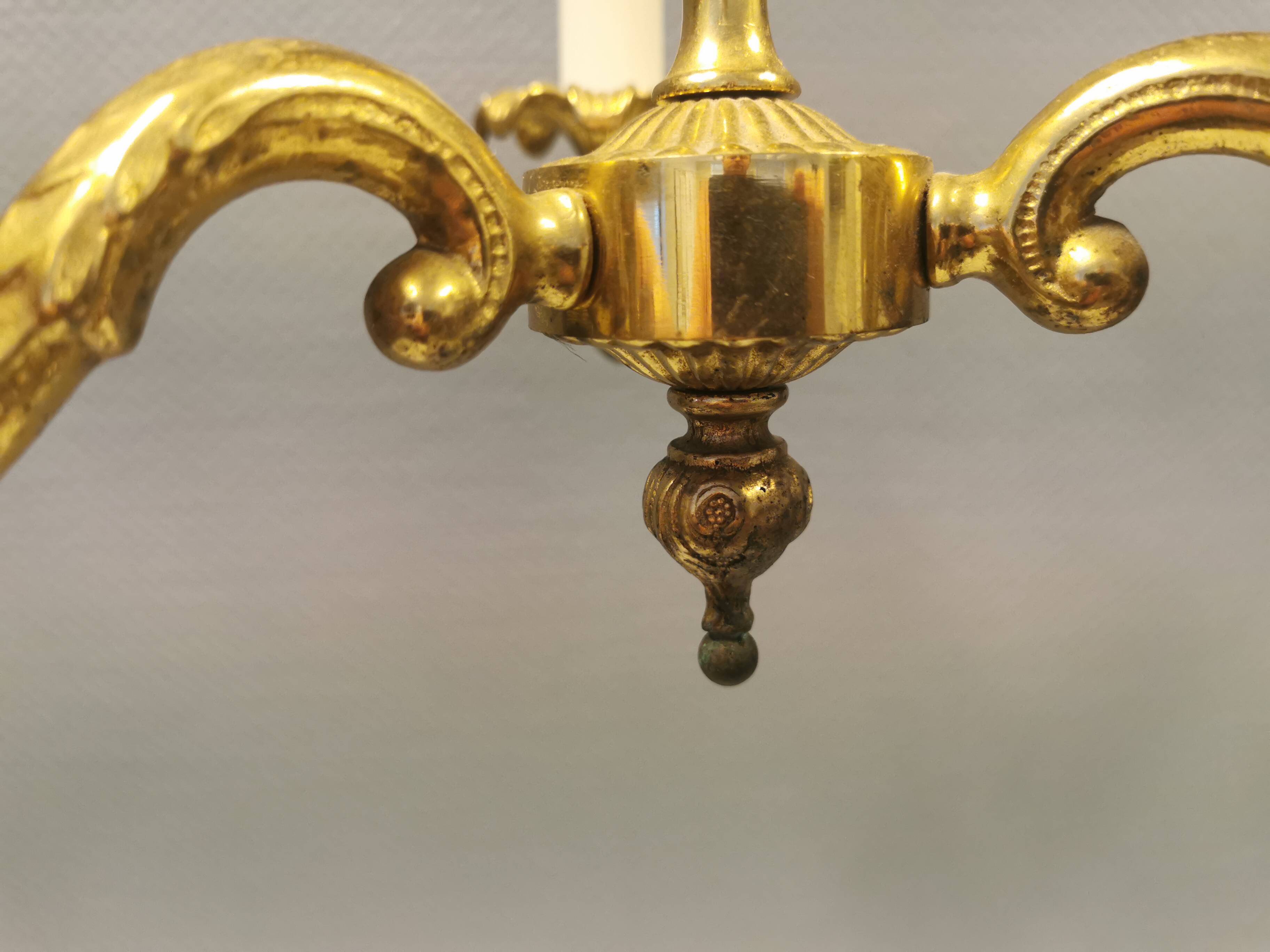 Older brass alloy chandelier with three light sources.