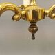 Older brass alloy chandelier with three light sources.