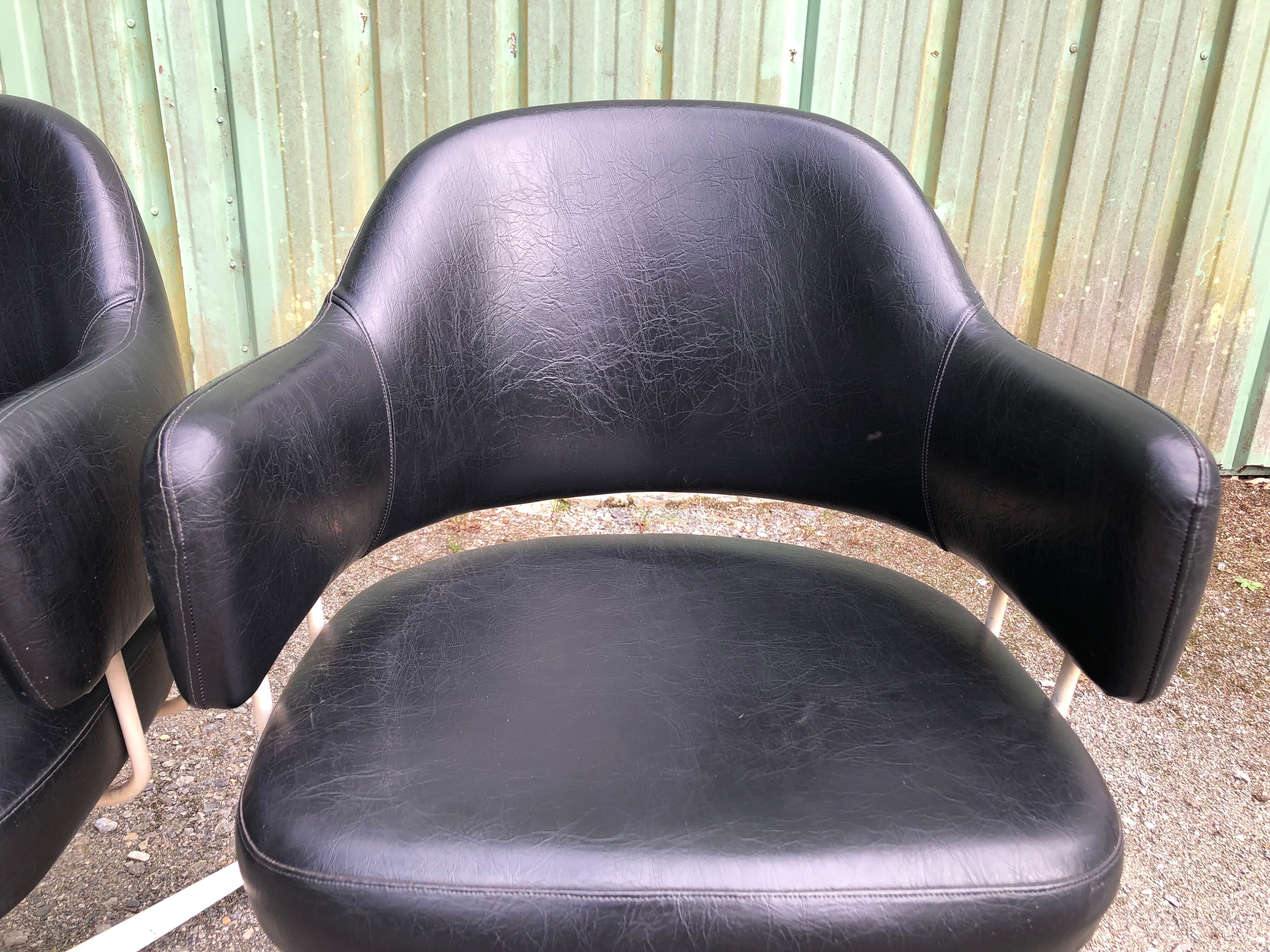 Pair of vintage armchairs in black skai with metal legs.