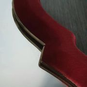 Vintage mirror with a scalloped shape in burgundy velvet and a golden trim.