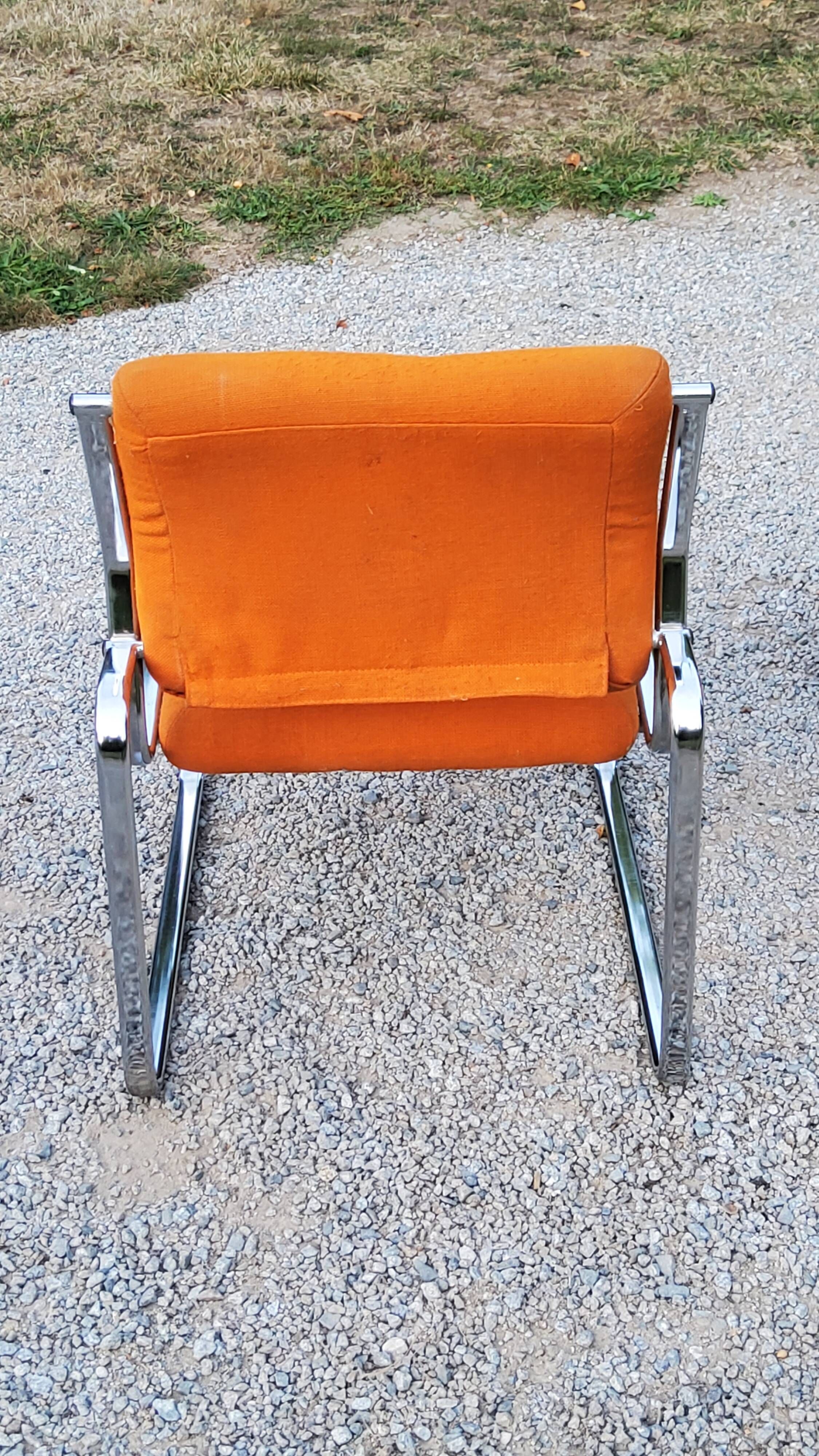 Pair of designer armchairs in orange fabrics and chrome tubes from the 70s