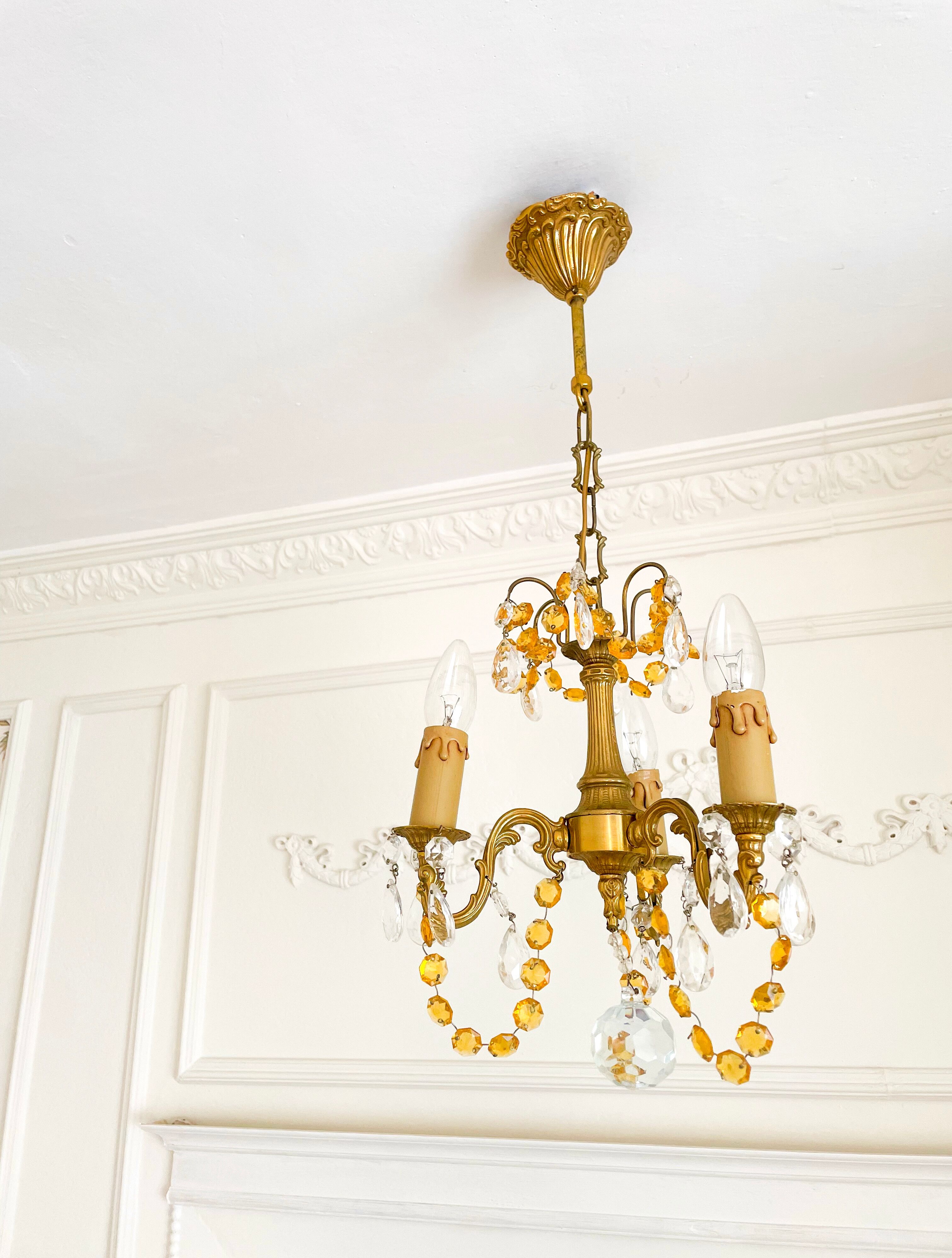 Small vintage brass chandelier with amber crystal pendants.