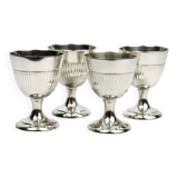 Four silver-plated Christofle egg cups with fluted sides.