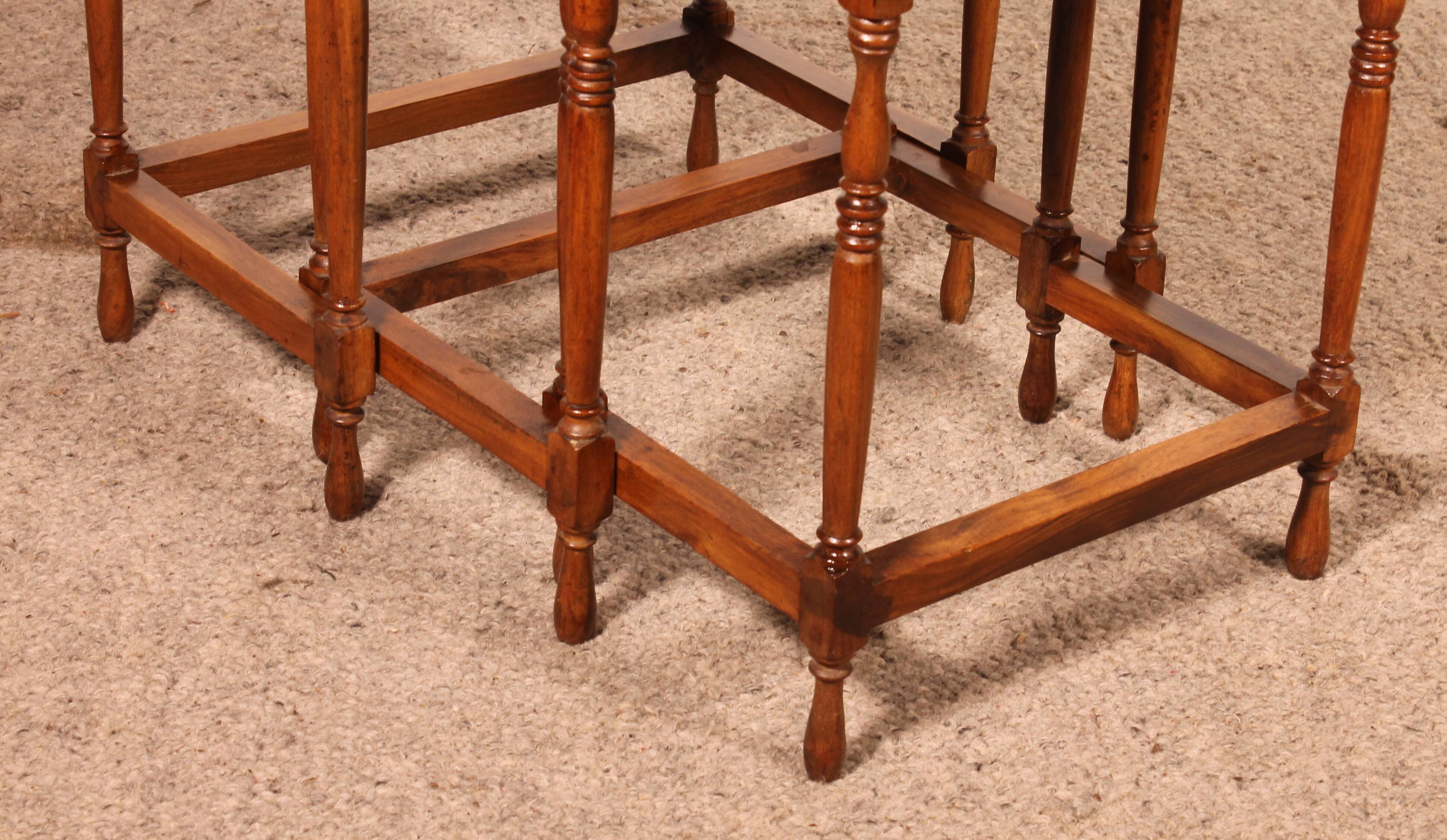 Nested tables in satin wood with brass inlays.
