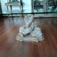 Glass table with carved wooden legs featuring intertwined fish.