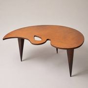 Mid-century coffee table with a palette shape and splayed legs.