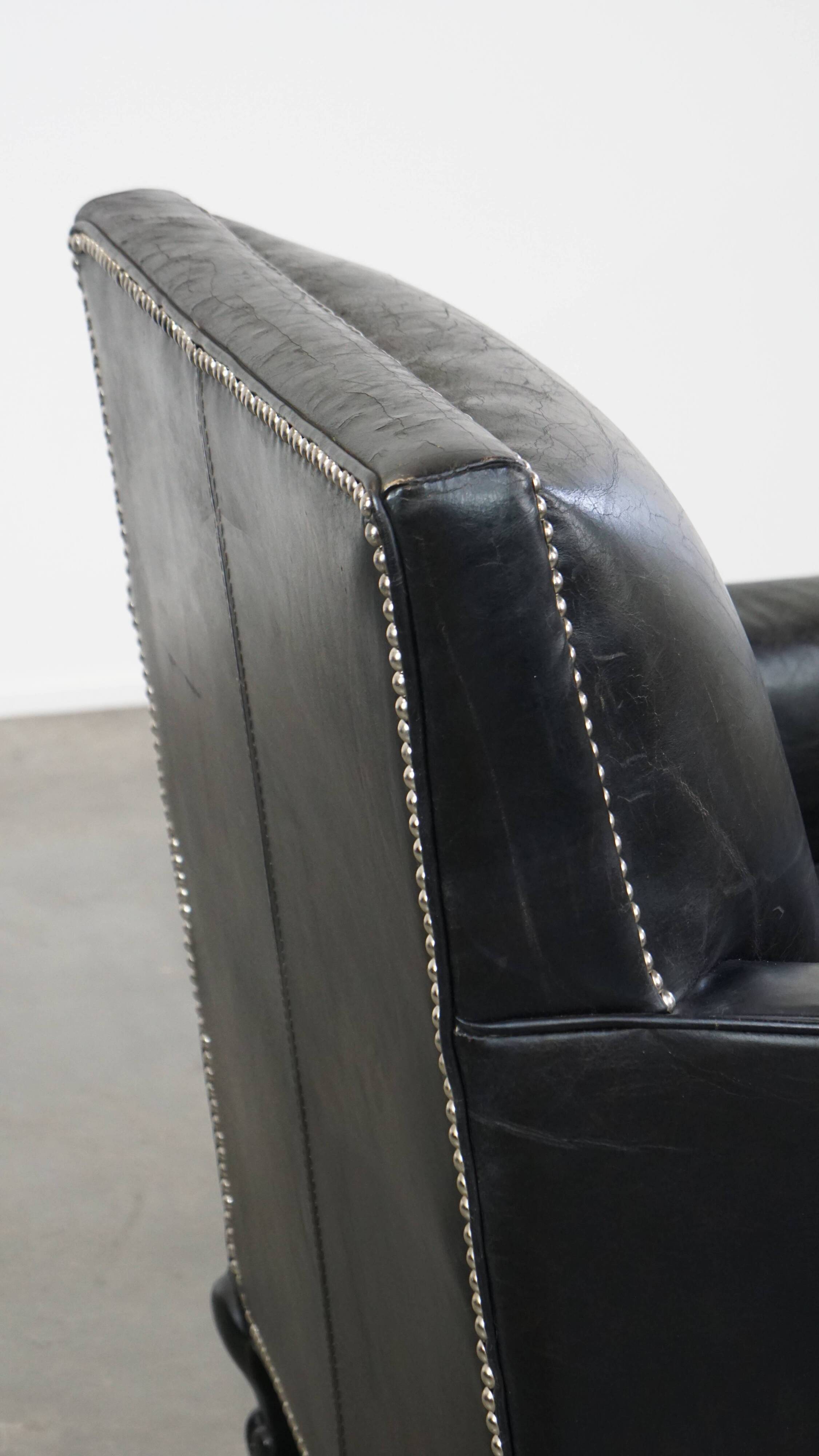 Armchair in black grained cowhide leather with a deep seat
