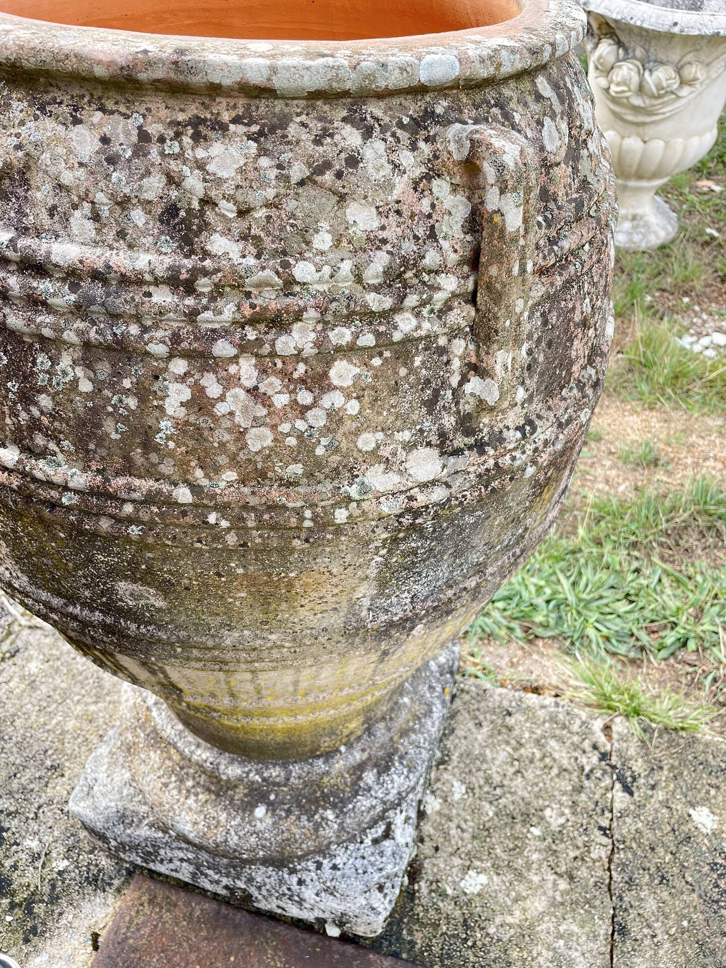Large Cretan jar in terracotta with three handles on a stone base.