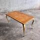 Table basse vintage avec pieds dorés et plateau incrusté de motifs géométriques en placage de bois brun clair
